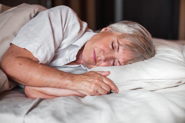 A woman sleeps deeply and peacefully, which may be a key factor in dementia prevention.